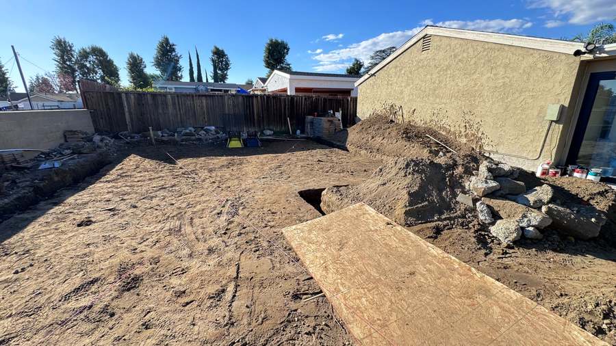 ADU pad dug out and graded next to a stucco house