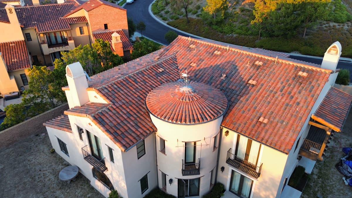Aerial view of a completed clay tile roof on a Mediterranean-style home with a round turret