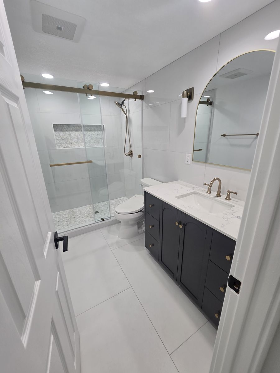 Remodeled bathroom with a glass-enclosed walk-in shower and a dark vanity
