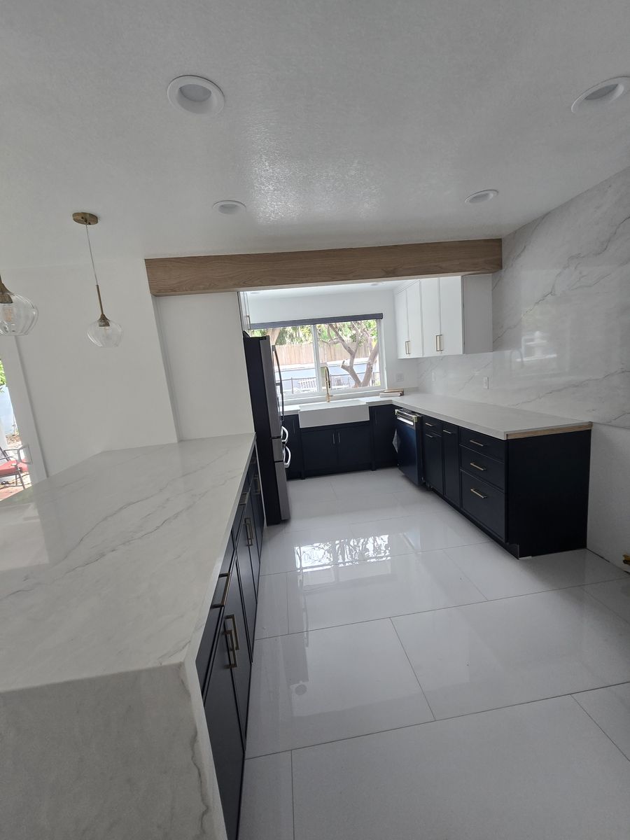 Navy kitchen cabinets and a long island with light counters after the Norwalk remodel