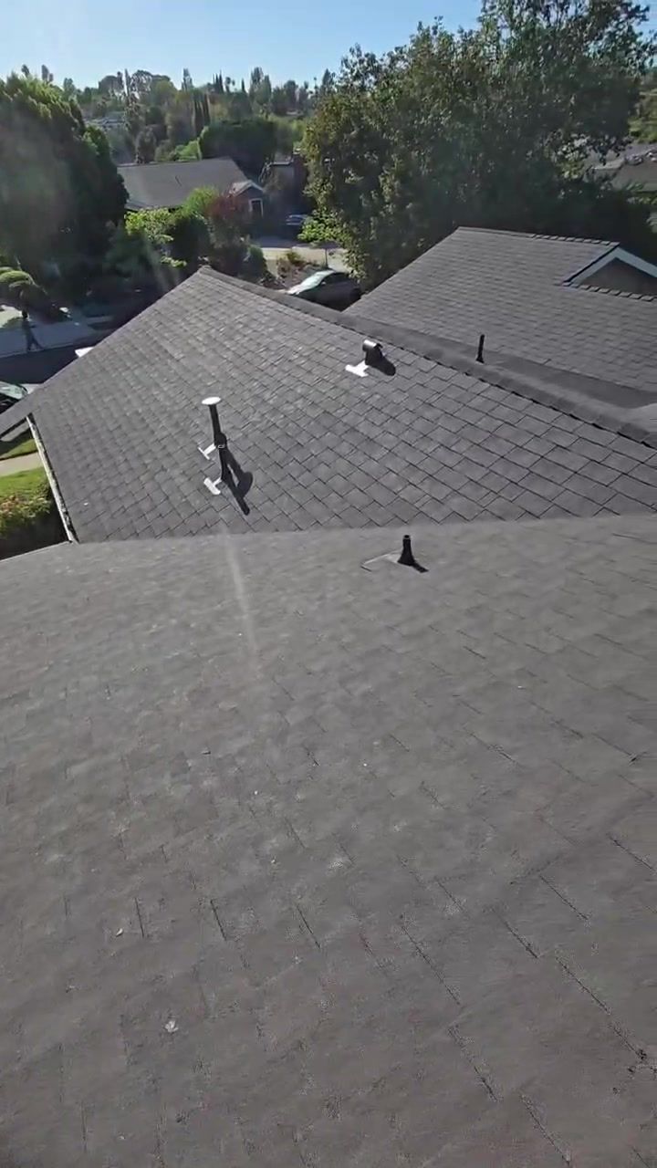Finished hip roof sections with new shingles and roof vents