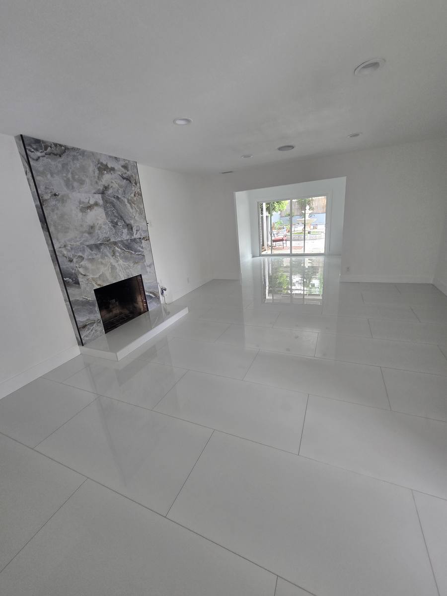 Floor-to-ceiling marble fireplace wall in a remodeled living room