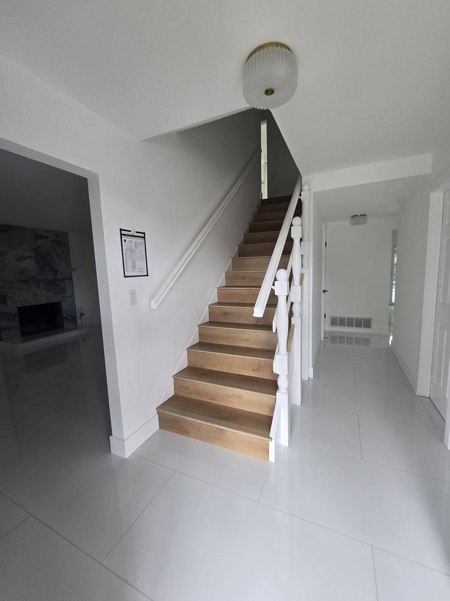 Remodeled entry with new wood stair treads and white railing
